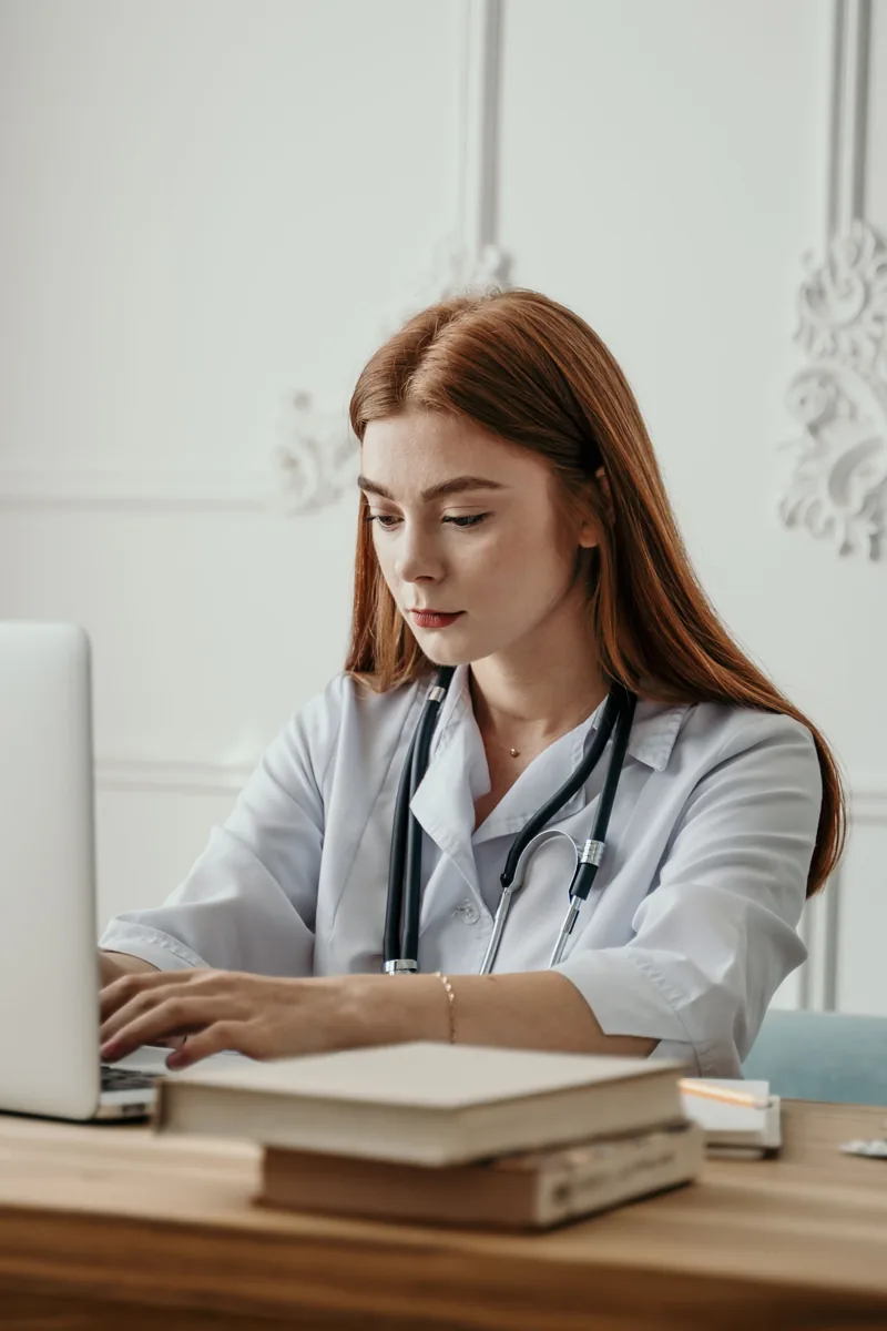 Healthcare provider working on a laptop in a clinical office