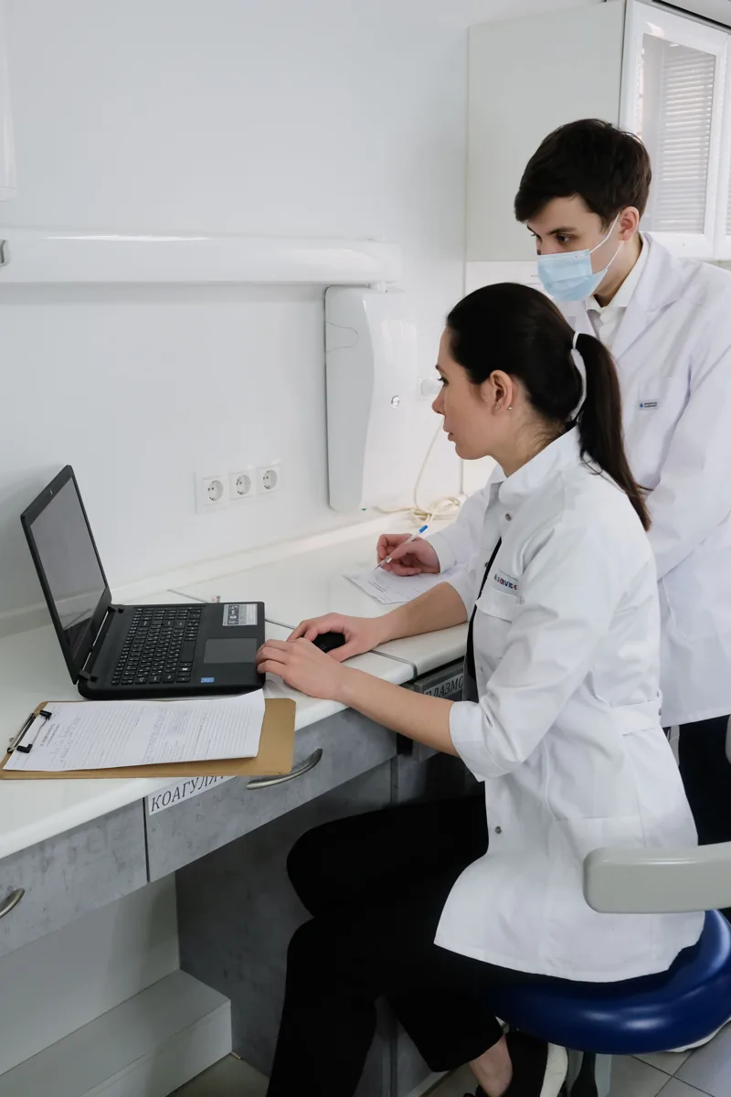 Medical professionals collaborating around a laptop